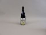 une bouteille de vin posée sur une table blanche