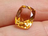 quelqu'un tient dans sa main un diamant jaune raffiné