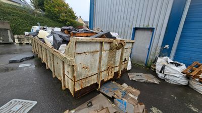 a dumpster full of garbage outside of a building