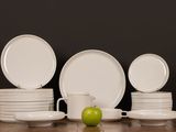 a stack of white plates and a green apple on the table