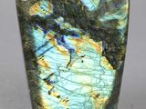 un gros plan d'une pierre verte et bleue posée sur une surface grise