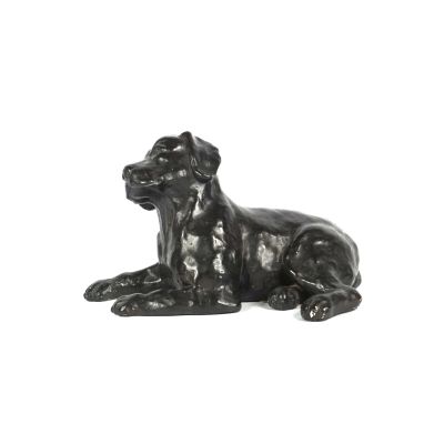 une statue représentant un chien couché sur une surface blanche