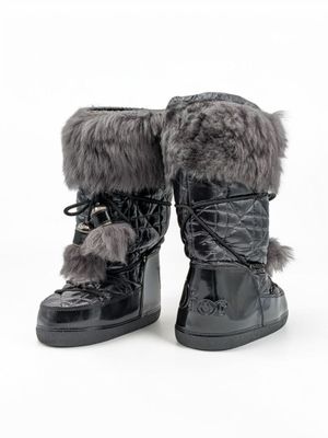 une paire de bottes noires ornées de fourrure, sur fond blanc
