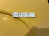 an old yellow car with a ruler on the side of it