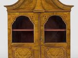 une armoire ancienne en bois à deux portes, dont l'une est vitrée