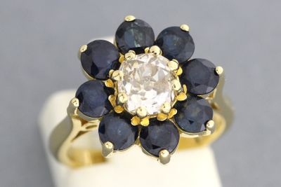 une bague en or sertie d'un diamant blanc et de saphirs bleus