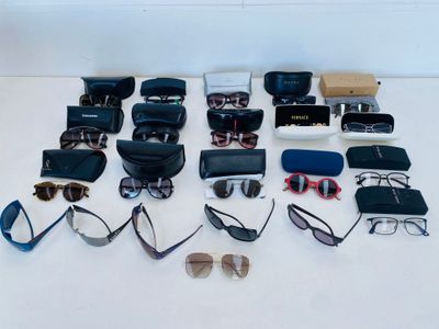 many pairs of glasses and sunglasses laid out on a table