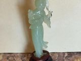 a statue of a woman holding a fan on a table