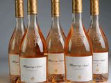Quatre bouteilles de vin rosé sont alignées sur une table