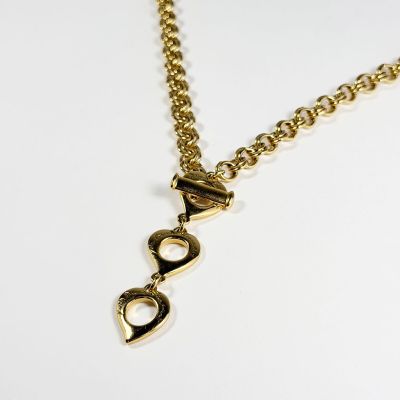 gros plan d'un collier en or sur une surface blanche