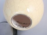 a white vase with a hole in it on a table