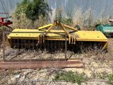 une charrue jaune au milieu d'un champ