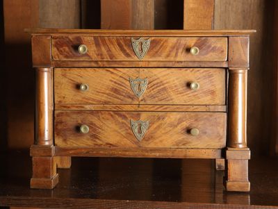 une petite commode en bois posée sur une table