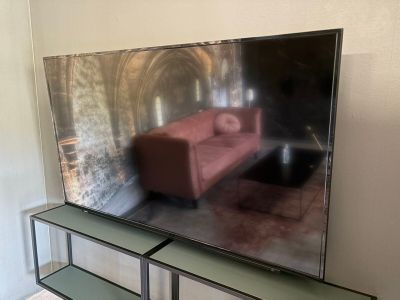 un grand téléviseur à écran plat posé sur une étagère en verre
