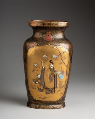 a gold vase with a picture of a man and a woman on it