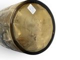 a gold vase with a black rim and a white label on it