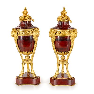 pair of antique red and gold vases on stands on a white surface