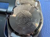a close up of a watch on a blue surface