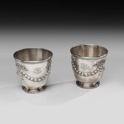 deux tasses en argent posées l'une à côté de l'autre sur une table