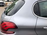 a dog sitting in the passenger seat of a silver car