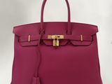 un sac Hermès rose avec un fermoir doré sur la poignée