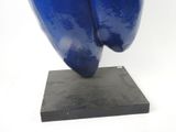 a blue sculpture on a black base on a white background