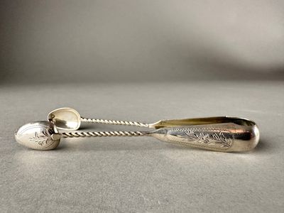 silver spoon and spoon rest on a table with a silver ball