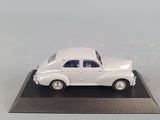 a white toy car on a black base on a table