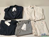 quatre paires de pantalons et une veste posés sur une table