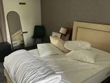 un grand lit avec des draps blancs et des oreillers dans une chambre