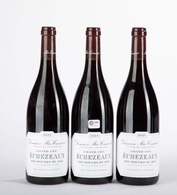 trois bouteilles de vin sont alignées sur une surface blanche