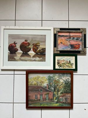 many pictures hanging on the wall of a bathroom
