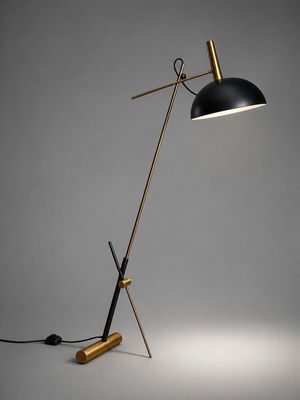 a black and gold floor lamp with a black shade on top of it