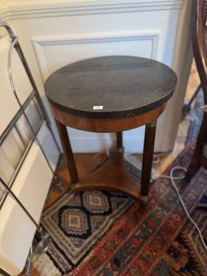 une petite table au plateau noir, dans un coin de la pièce