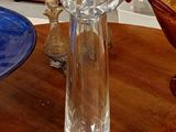 un vase en verre posé sur une table à côté d'un bol bleu