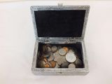 a small silver box filled with coins on a table