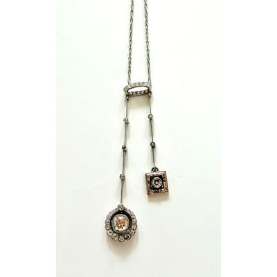 gros plan d'un collier sur une surface blanche avec une chaîne