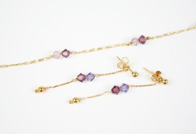 gros plan d'un collier et de boucles d'oreilles sur une surface blanche