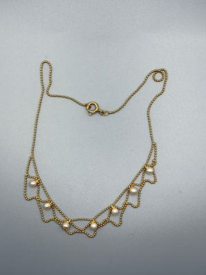 un collier en or avec des perles sur une chaîne