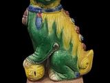 chinese figurine of a dog on a box with a black background