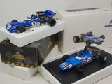 two models of racing cars on display in a box