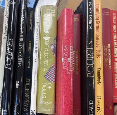 de nombreux livres qui se trouvent sur une étagère dans la pièce