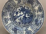 blue and white plate with a design of birds and flowers on it