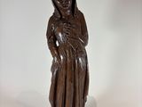 wooden statue of a woman holding a baby in her arms