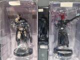 two boxes of action figures on display in a glass case