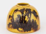 un vase jaune orné d'un motif en noir et blanc