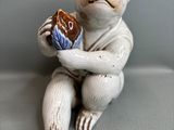 une figurine représentant un singe tenant un beignet