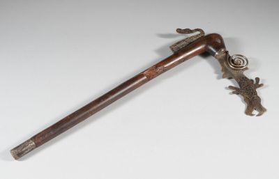 an old wooden stick with a metal handle on a white surface