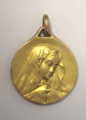 Gros plan sur une médaille d'or portant le visage d'une femme