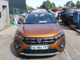 une voiture orange garée sur un parking, avec d'autres voitures en arrière-plan